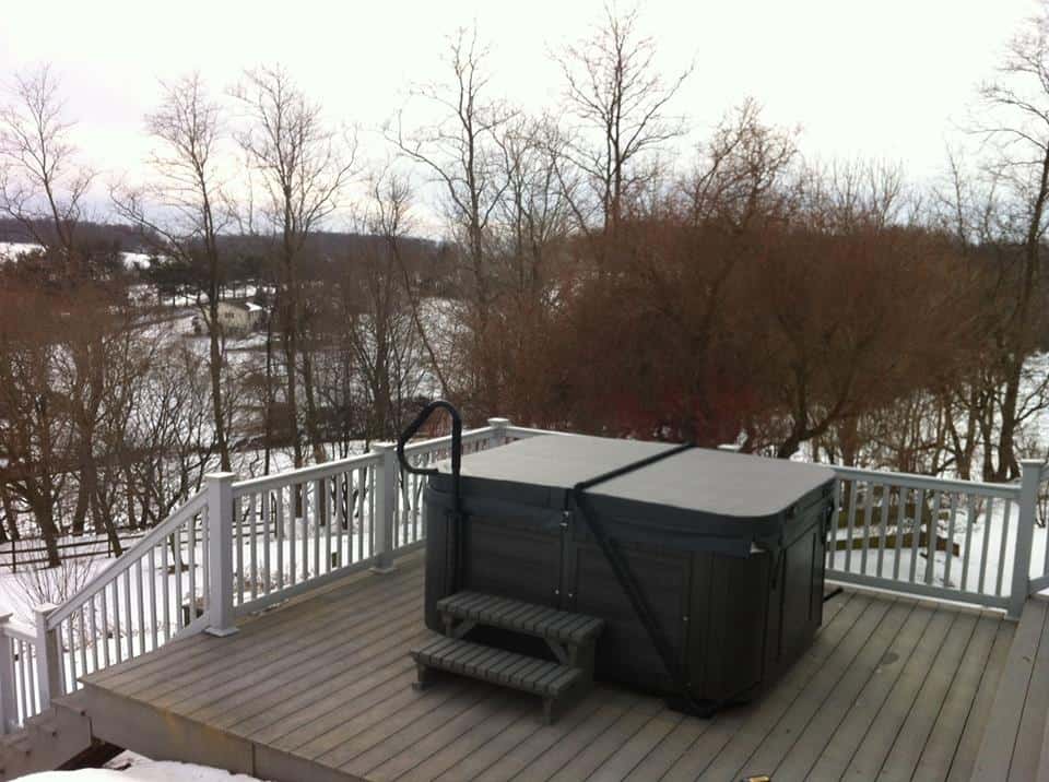 Covered Arctic Spas Hot tub in the backyard in winter