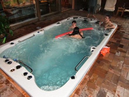 Family having fun in an arctic spas swim spa inside a house