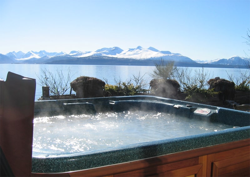 arctic spas hot tub with a view of lake and mountains covered with snow view